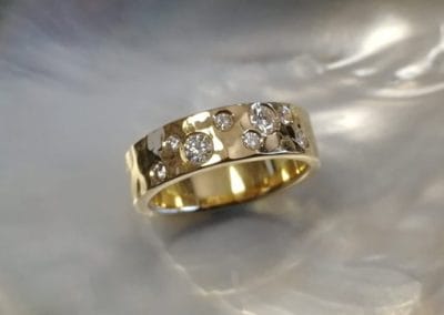 Bague ruban martelée en or jaune ornée de diamants